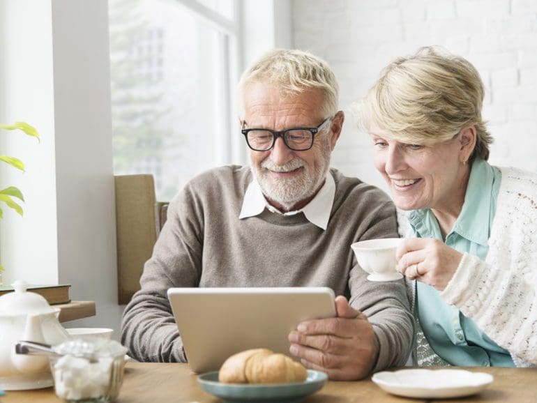 Elderly couple look at computer